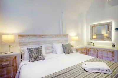 a bedroom with a large white bed and a mirror at Rhodos Horizon Blu-Adults Only in Rhodes Town