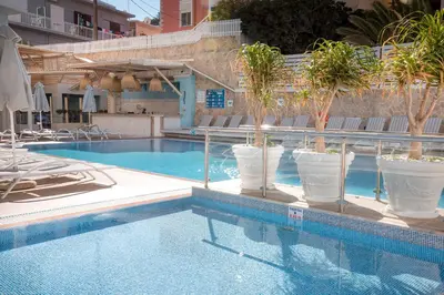 a swimming pool with palm trees in a hotel at Rhodos Horizon Blu-Adults Only in Rhodes Town