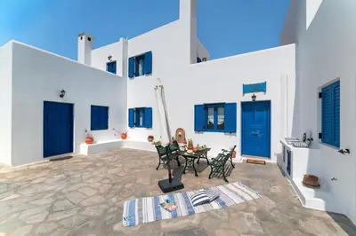 a patio with blue doors and a table with chairs at Irene's house in Lachania