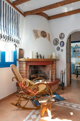 a living room with a fireplace and a rocking chair at Irene's house in Lachania
