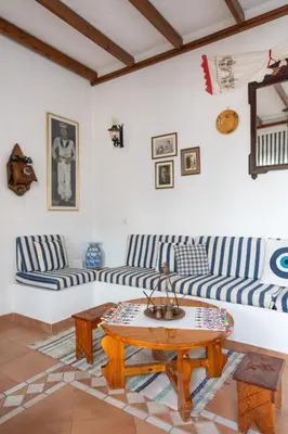 a living room with blue and white striped couches and a table at Irene's house in Lachania