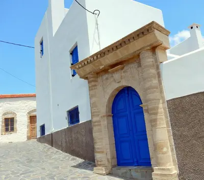 a blue door on the side of a white building at Irene's house in Lachania