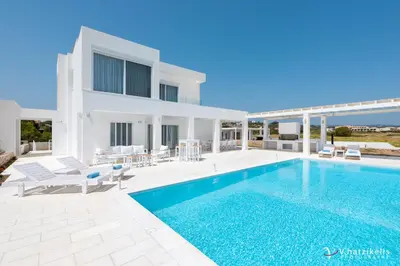 a villa with a swimming pool and a house at Maria & Nada Beachfront Villas in Kolimbia