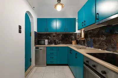 a kitchen with blue cabinets and a sink at A Unique 3-4 bedrooms house in OLD TOWN in Rhodes Town