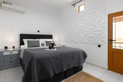 a bedroom with a large bed with a gray blanket at A Unique 3-4 bedrooms house in OLD TOWN in Rhodes Town
