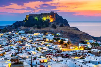 a view of a town with a mountain in the background at Bakia Lindos in Líndos