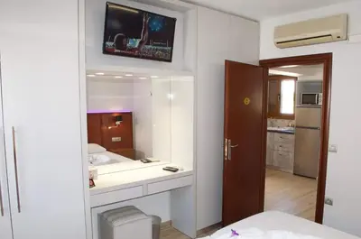 a bathroom with a sink and a tv on the wall at Bakia Lindos in Líndos