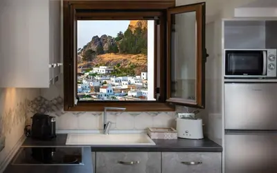 a kitchen with a sink and a window with a view at Bakia Lindos in Líndos