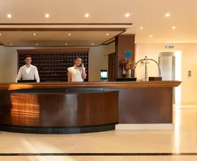 two men standing behind a bar in a hotel lobby at Canvas by Mitsis Petit Palais in Rhodes Town