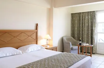 a bedroom with a bed and a chair and a window at Canvas by Mitsis Petit Palais in Rhodes Town