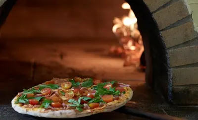 a pizza is coming out of a brick oven at Canvas by Mitsis Petit Palais in Rhodes Town