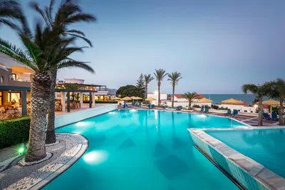 a swimming pool with palm trees in a resort at Mitsis Rodos Maris in Kiotari