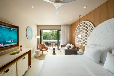 a bedroom with a large bed and a living room at Mitsis Rodos Village in Kiotari