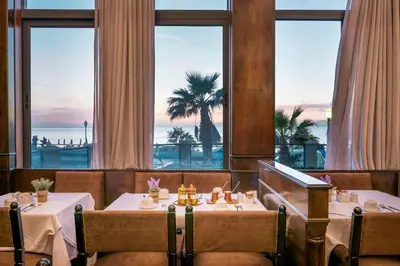 a restaurant with two tables and a view of the ocean at Mitsis La Vita in Rhodes Town