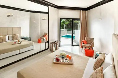 a living room with a bed and a room with a pool at Mitsis Faliraki in Faliraki