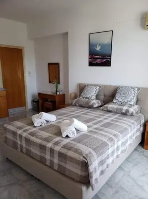 a bedroom with a large bed with towels on it at Haraki Sunrise Apartments in Haraki