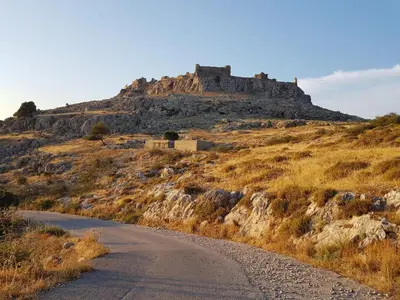 a road with a castle on top of a hill at Haraki Sunrise Apartments in Haraki
