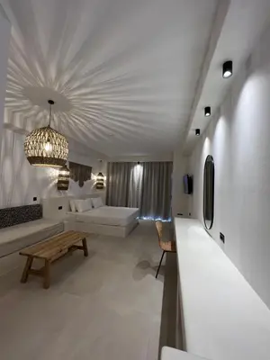 a living room with a couch and a chandelier at Pefkos Blue in Pefki Rhodes
