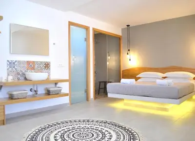 a bedroom with a king sized bed and a bathroom at Lindos SeaSide Suite in Líndos
