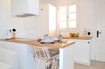 a kitchen with a counter with a table at Lindos SeaSide Suite in Líndos