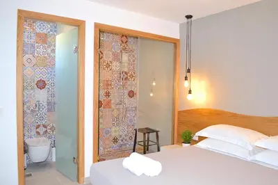 a bedroom with a bed and a bathroom with a shower at Lindos SeaSide Suite in Líndos