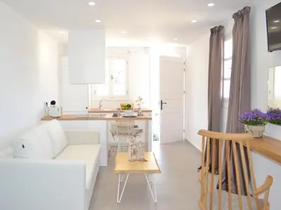 a white living room with a white couch and a table at Lindos SeaSide Suite in Líndos