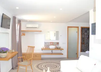 a living room with a table and a chair at Lindos SeaSide Suite in Líndos
