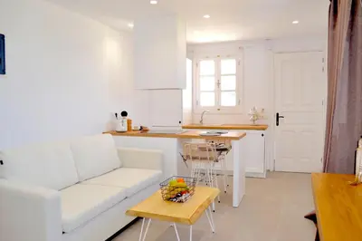 a living room with a white couch and a table at Lindos SeaSide Suite in Líndos