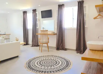 a bathroom with a tub and a table and a chair at Lindos SeaSide Suite in Líndos