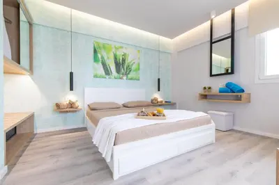 a bedroom with a white bed and a blue wall at Akalli Studios in Ixia