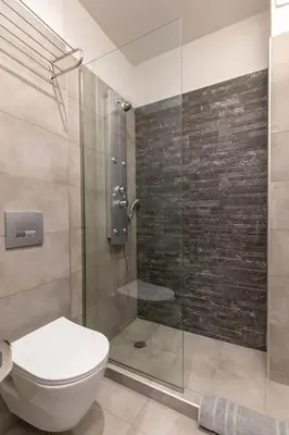 a bathroom with a toilet and a glass shower at Akalli Studios in Ixia