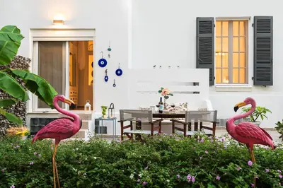 two pink flamingos in a garden in front of a house at Monte Smith Hill in Rhodes Town