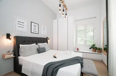 a white bedroom with a large bed with white sheets at Monte Smith Hill in Rhodes Town