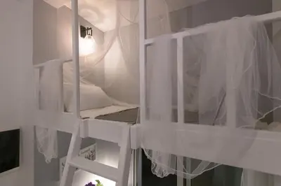 a white bunk bed with white curtains in a room at Monte Smith Hill in Rhodes Town