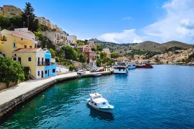 a small boat in a river in a town at Marias Sea House in Symi