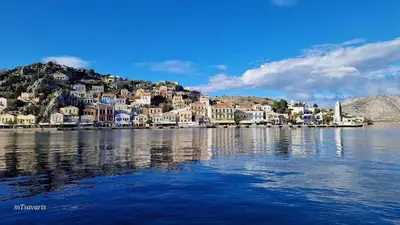 a town on top of a hill next to the water at Marias Sea House in Symi