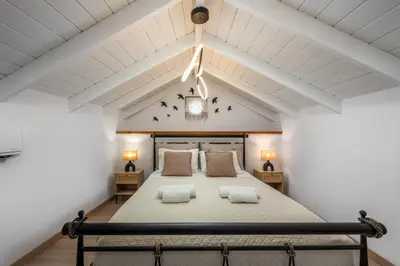 a bedroom with a large bed with two pillows at Marias Sea House in Symi