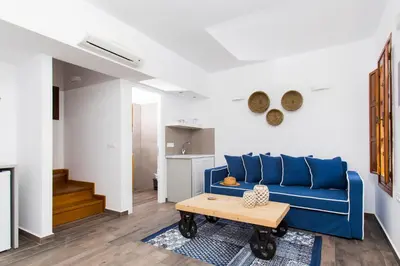 a living room with a blue couch and a table at Lindos Del Mar Suites - Adults Only in Líndos