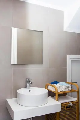 a bathroom with a white sink and a mirror at Lindos Del Mar Suites - Adults Only in Líndos