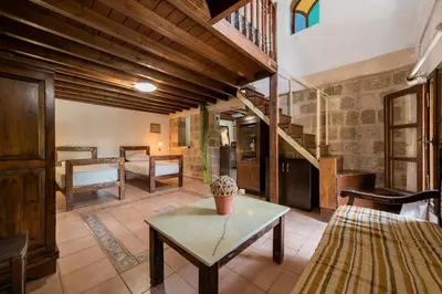a living room with a table and a staircase at Secret Garden - Old Town in Rhodes Town