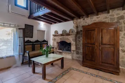 a living room with a stone fireplace and a table at Secret Garden - Old Town in Rhodes Town