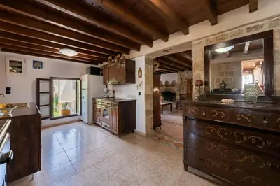 a large kitchen with wooden cabinets and a table at Secret Garden - Old Town in Rhodes Town
