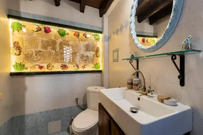 a bathroom with a sink and a toilet and a mirror at Secret Garden - Old Town in Rhodes Town