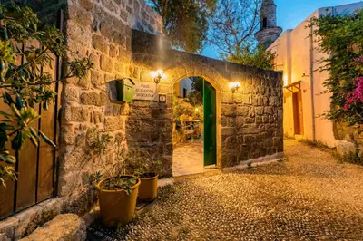 an alleyway with a green door in a stone building at Secret Garden - Old Town in Rhodes Town