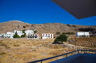 a view of a village with a mountain in the background at Lindos Portes Suites - Adults Only in Líndos