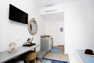 a room with a desk and a tv on the wall at Lindos Portes Suites - Adults Only in Líndos
