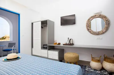 a bedroom with a bed and a mirror at Lindos Portes Suites - Adults Only in Líndos