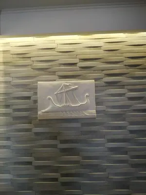 a wall with a white sign on a brick wall at Antonios Hotel in Faliraki