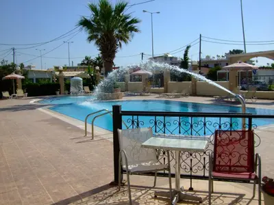 a fountain in front of a swimming pool at Antonios Hotel in Faliraki