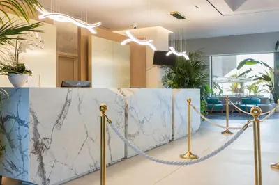 a lobby with a marble counter with two lights at Pegasos Deluxe Beach Hotel in Faliraki